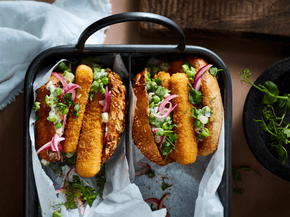 Burger aux fish sticks végétariens avec des petits pois, cornichons et oignon rouge